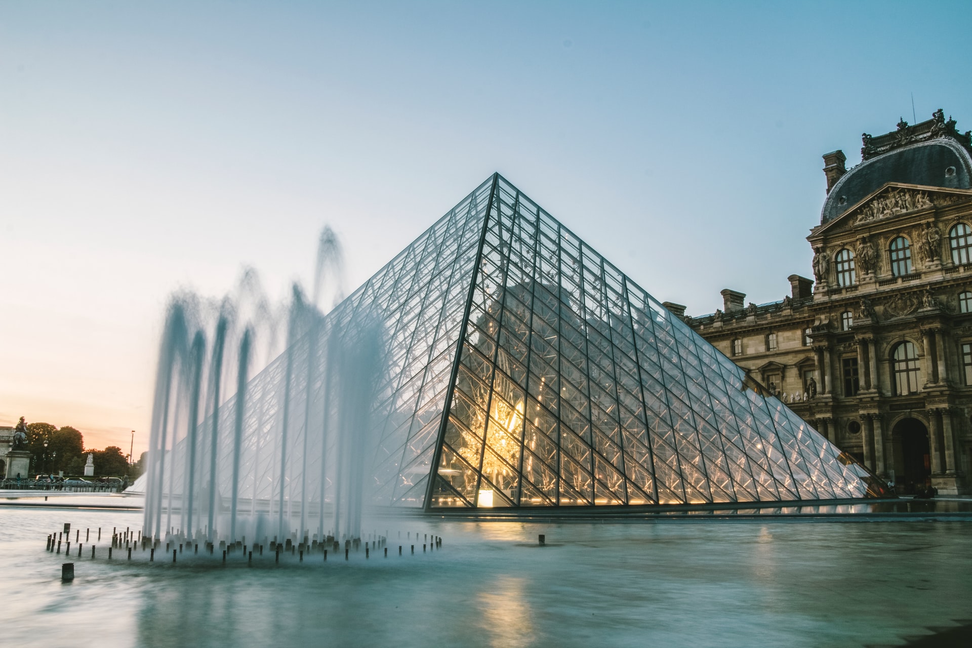 Louvre Pyramid at night with fountains in foreground