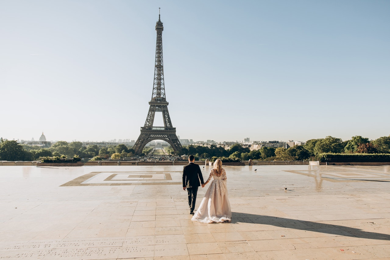 Couple holding hands at the Eiffel Tower