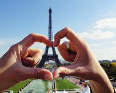 Heart shaped hands around the Eiffel Tower in Paris