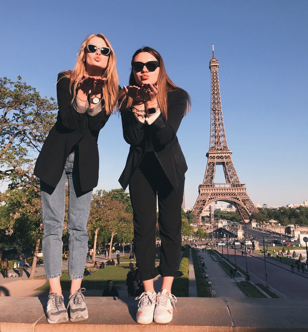 Women blowing kissed in front of the Eiffel Tower for a photo